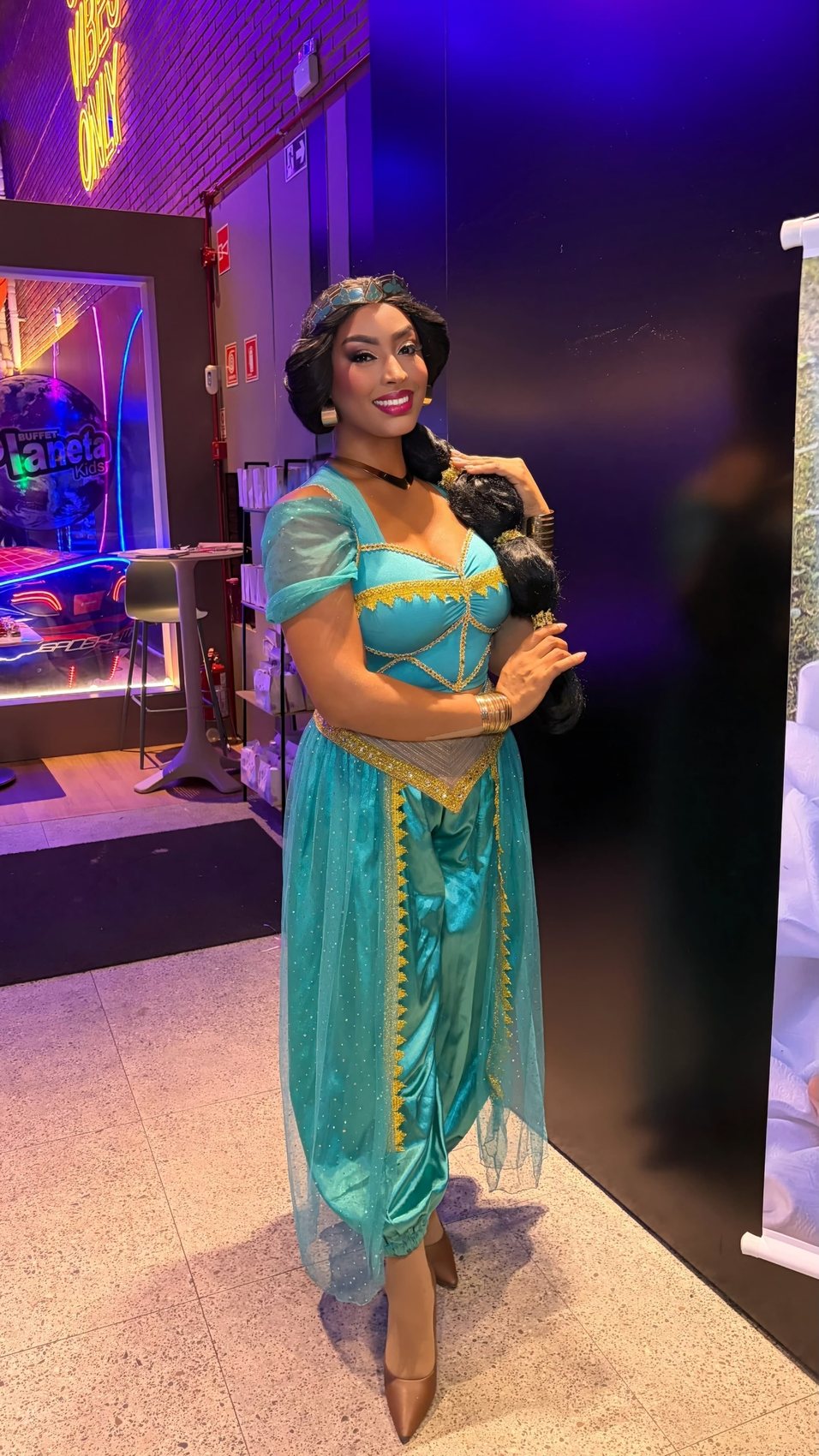 Princesa de traje turquesa e dourado com longa trança escura