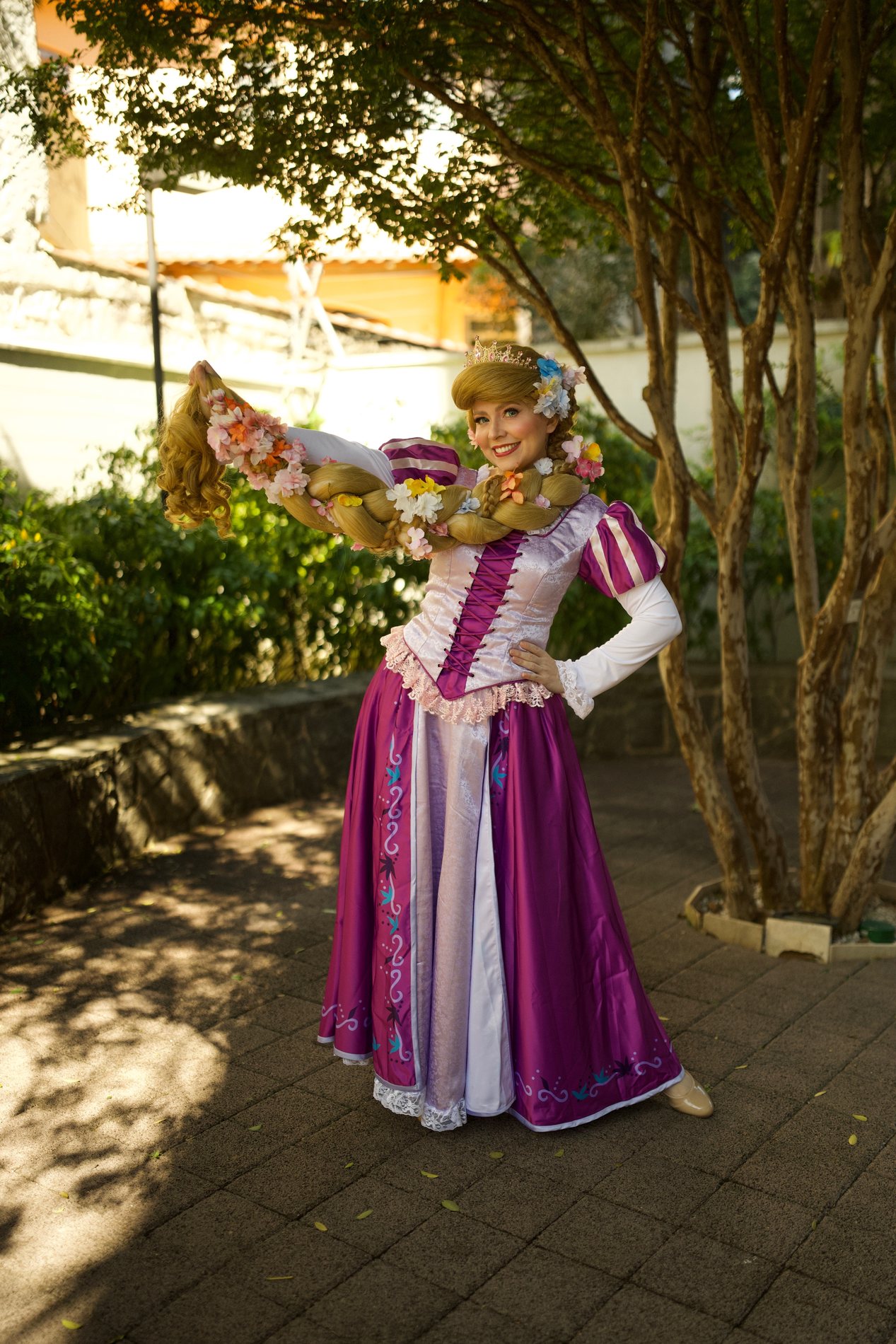 Princesa da torre segurando a longa trança florida no jardim